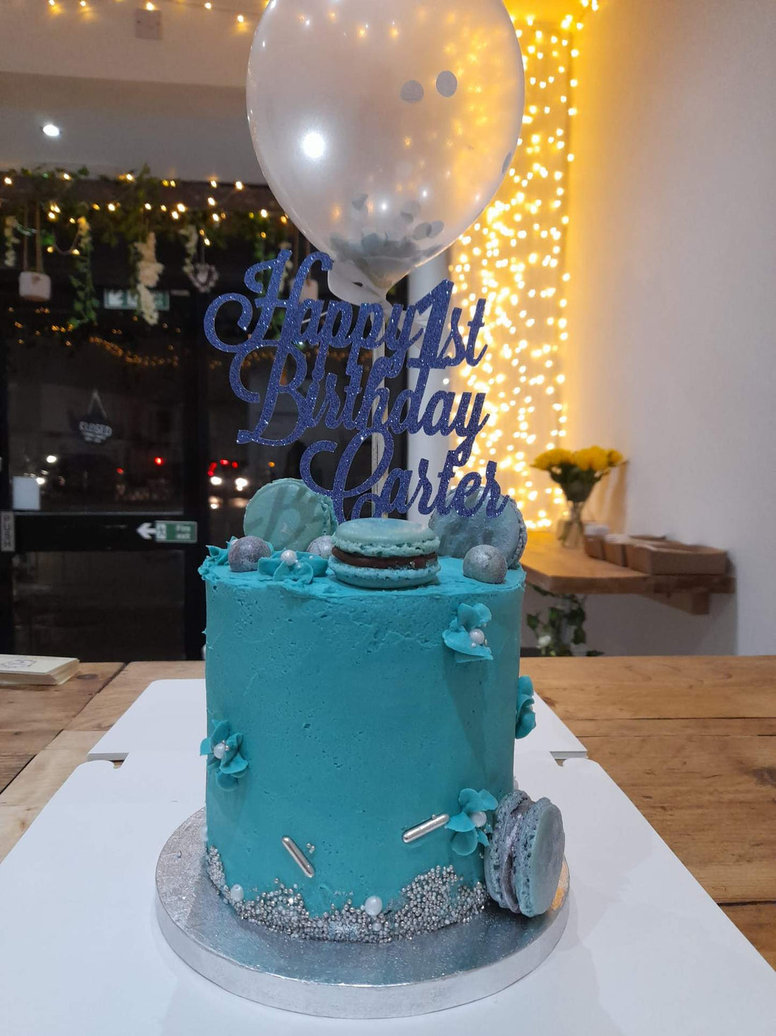 Celebration cake, A six inch baby blue, 4 layered vanilla drip cake topped with a confetti balloon.