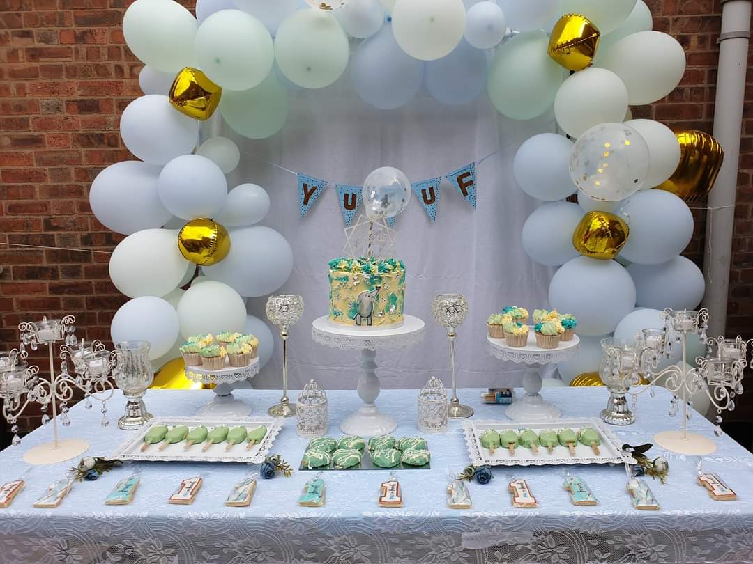 Celebration cake, dessert table. Vanilla strawberry buttercream cake, topped with a balloon, cake topper, textured buttercream, silver edible leaf, silver edible sprinkles and a hand painted elephant.