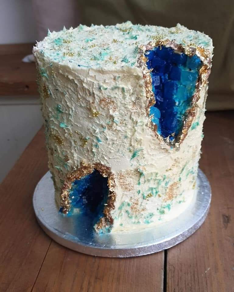 A simple 6 inch buttercream and strawberry geode cake.  The geode effect has been made using sugar canes and then painted in blue to match the theme and then topped with gold paint and edible gold leaf. 